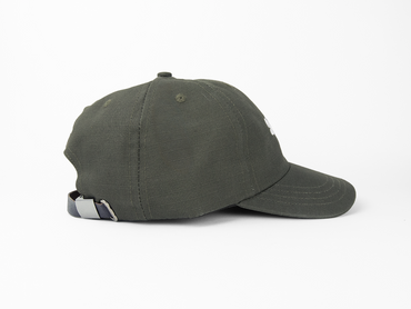 A side view of an olive baseball cap showing a leather closure and nickel hardware