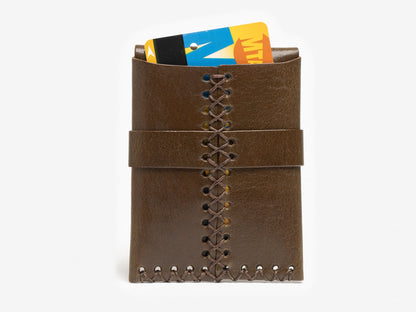 A olive leather card holder with decorative stitching down the center, holding two plastic cards, one yellow and blue and another partially visible, against a white background.