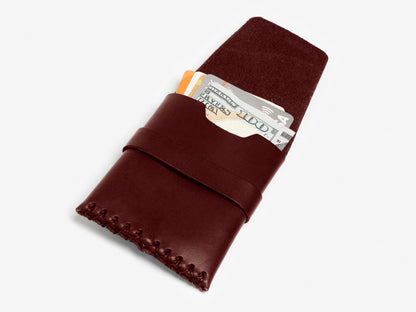 A brown leather wallet with stitched edges, partially open to reveal cash and credit cards inside, displayed on a white background.