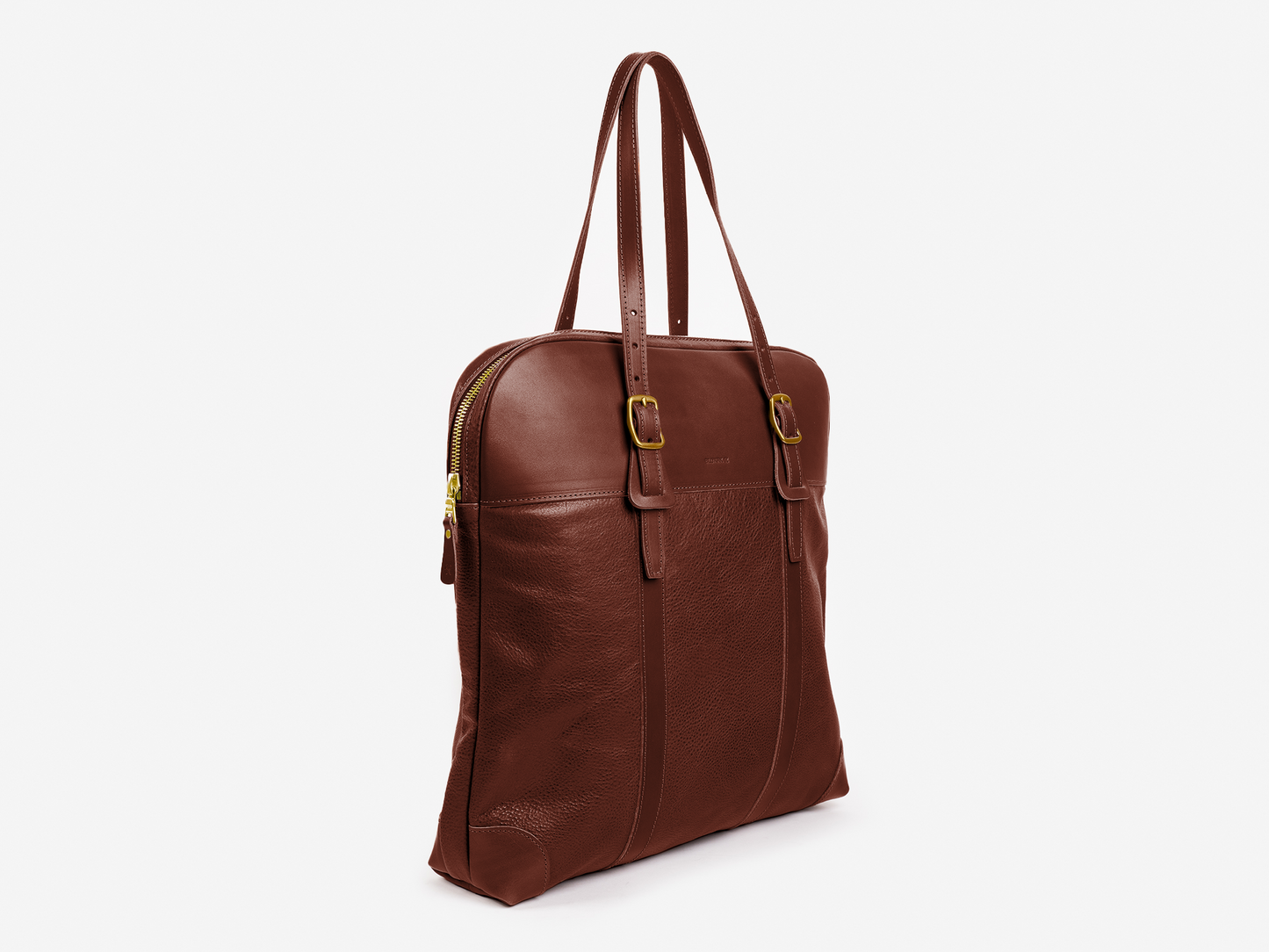 A brown leather tote bag with two shoulder straps, gold-tone buckles, and a zippered top, displayed against a plain white background.