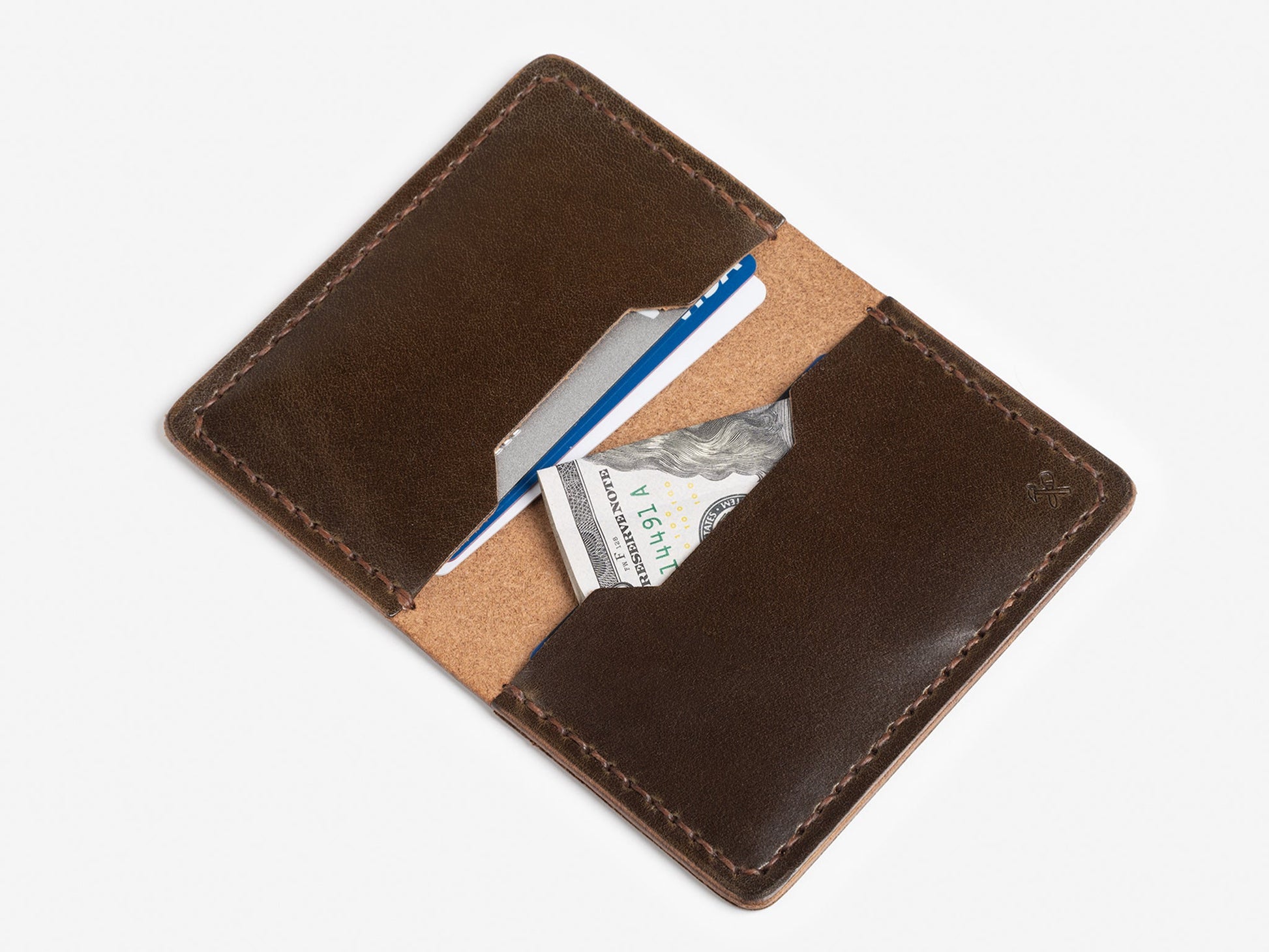 A brown leather wallet open to reveal a blue credit card, a white card, and a folded U.S. twenty-dollar bill against a white background.