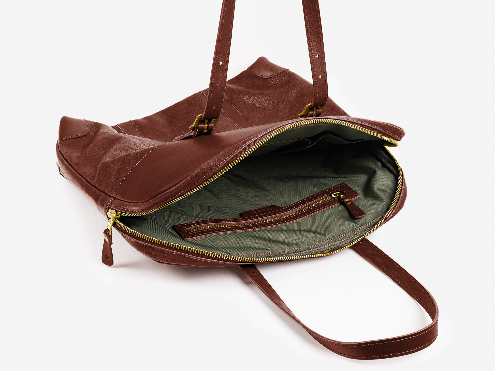 A brown leather shoulder bag with gold zipper, opened to show a green interior lining and an inner zippered pocket. The bag has two handles and is photographed on a white background.