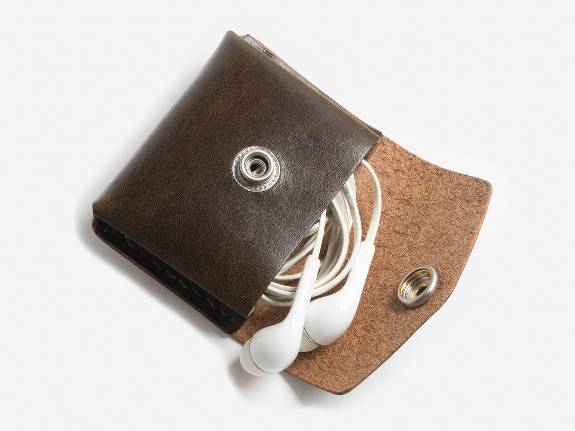 An olive leather coin pouch with a snap closure, displayed with earphones partially pulled out from it.