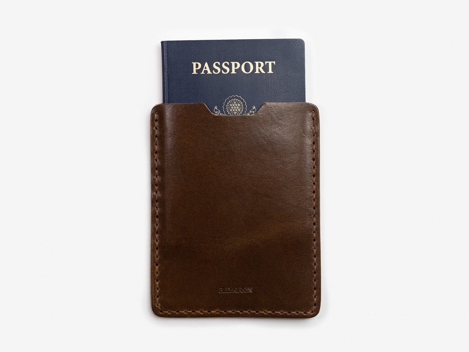 A dark brown leather passport holder with a blue passport partially visible inside, set against a plain white background.
