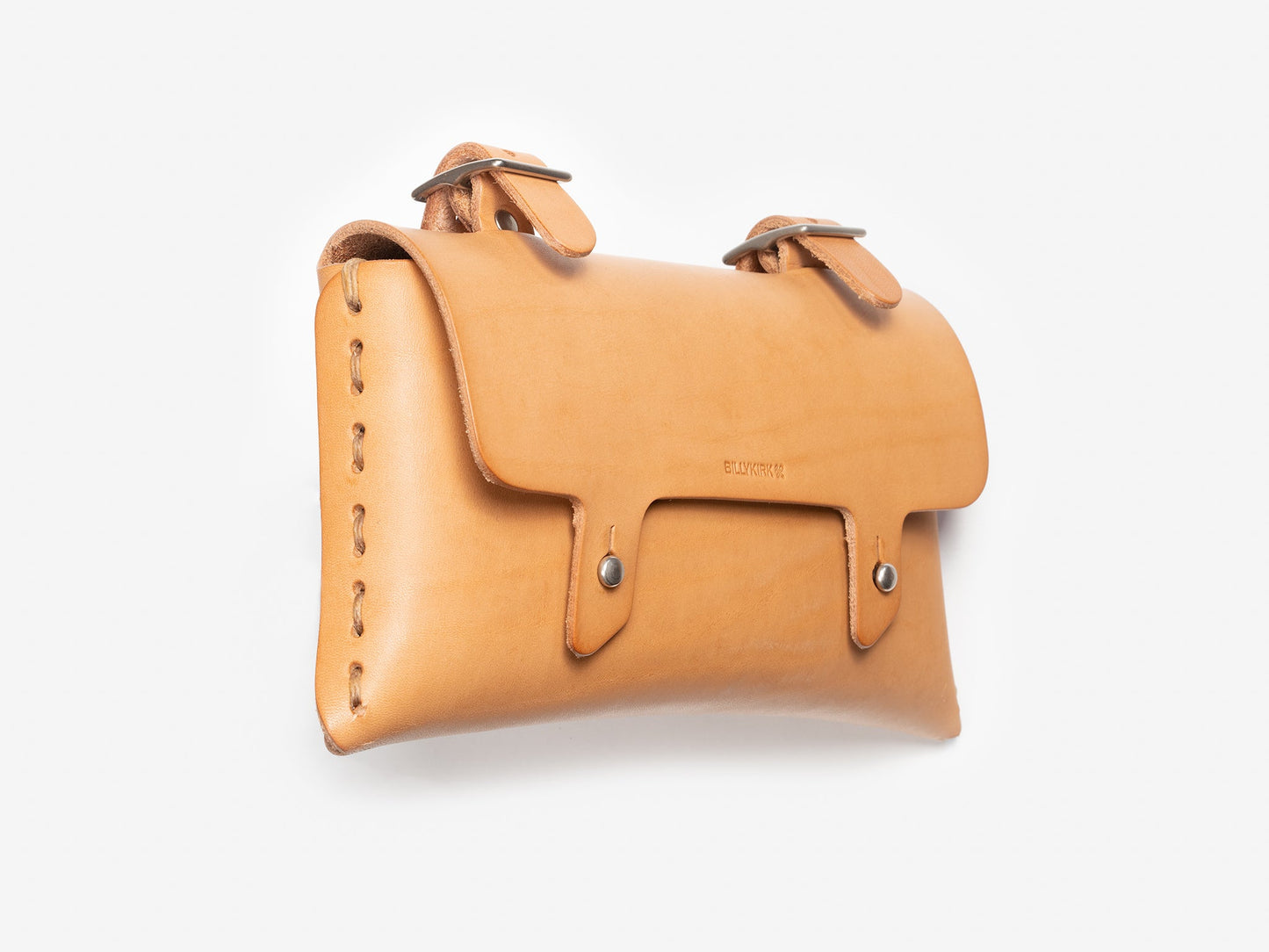 A tan leather pouch with stitching along the side, two metal buckles on top, and a flap secured by two metallic buttons. The pouch is photographed against a plain white background.