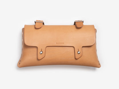 A tan leather satchel with a flap closure, two buckle straps, and silver button accents on the front, set against a white background.