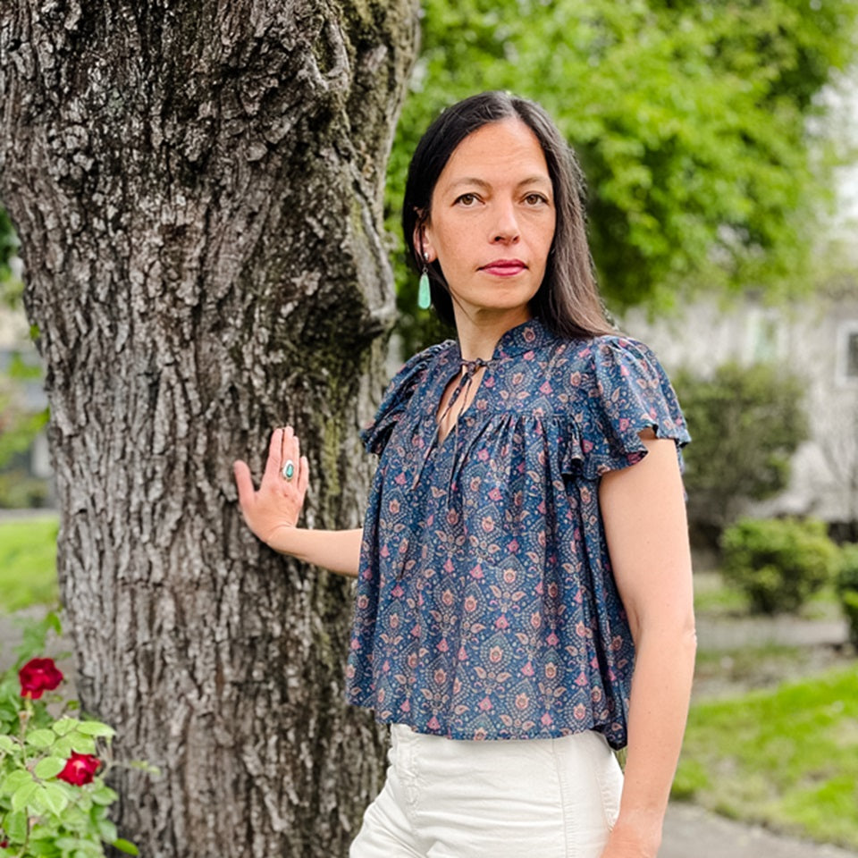 Ginew co-founder Amanda wearing silk paisley ruffle shirt and cream carpenter pants