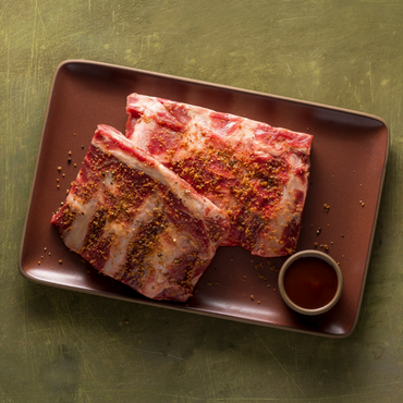 Grass Roots Farmers' Co-op Beef Back Ribs are the meat remaining after the butcher removes the ribeye roast off the bones. Lean with plenty of meat between the bones. Smoke, braise, or slow-roast in the oven. These ribs are hard to find and a Grass Roots' butcher's favorite. We cut the slab in half so you have two 4-rib slabs per package. Check our blog for BBQ sauce recipes that will go great with these ribs.