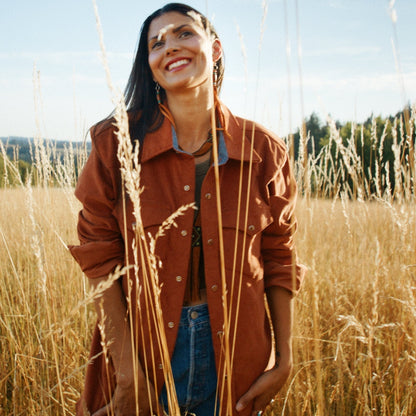 Orange corduroy shirt on Native American woman in field