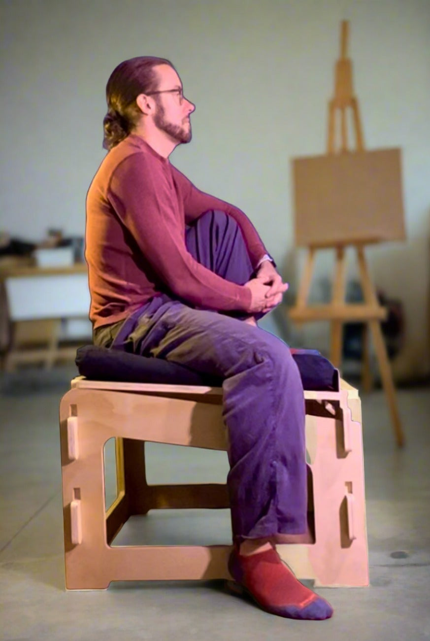 man sitting on a higher ground sage chair for active sitting in workshop studio