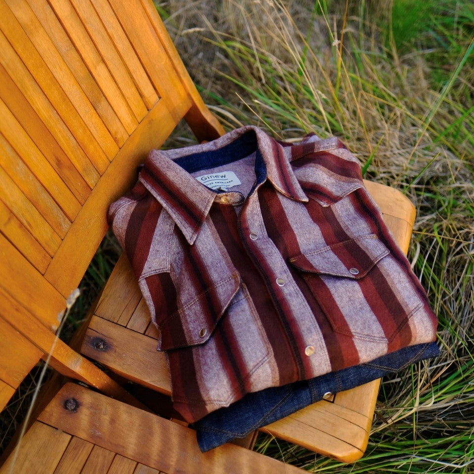 Folded brown stripe all cotton flannel shirt on outside chair