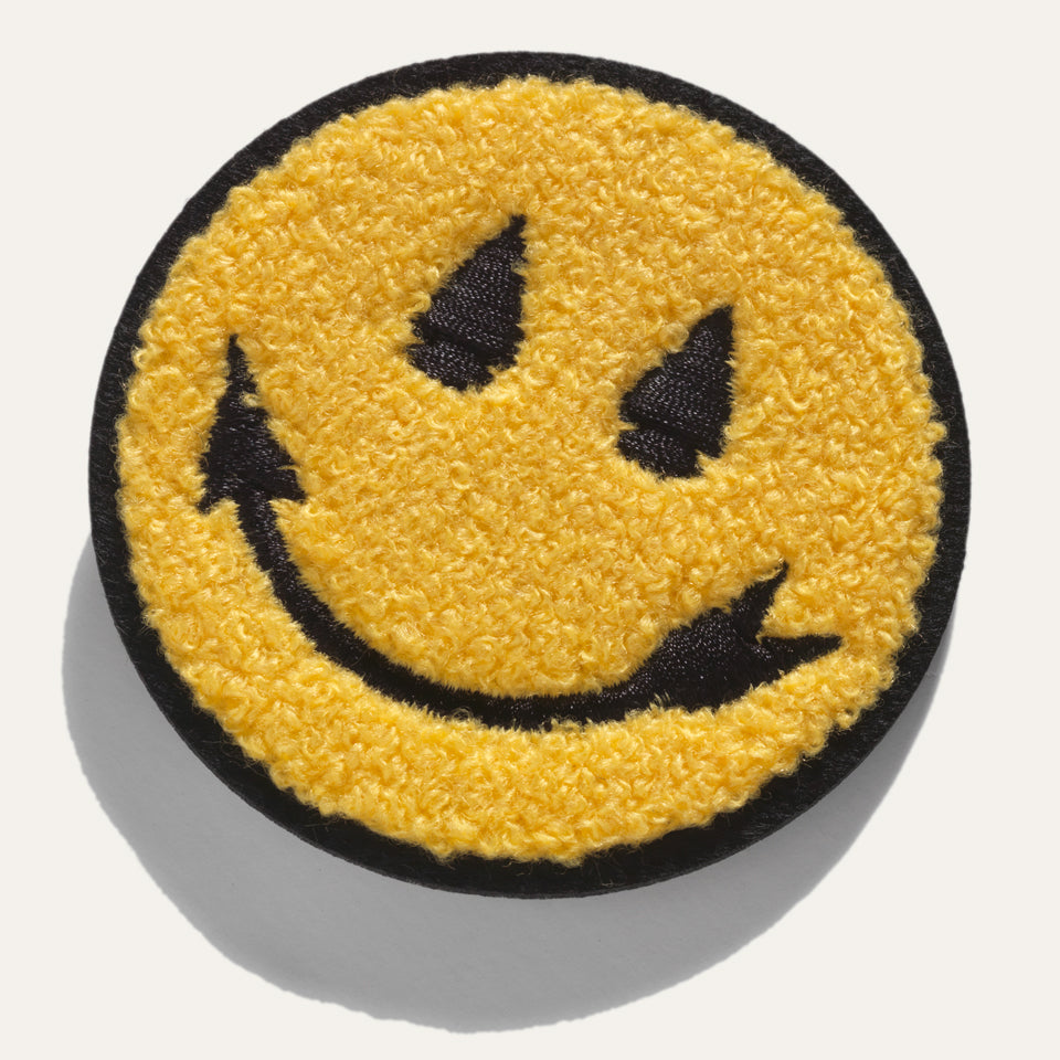 Chenille smiley face sew on patch designed by Native American Steven Paul Judd with arrowhead smile and eyes. 