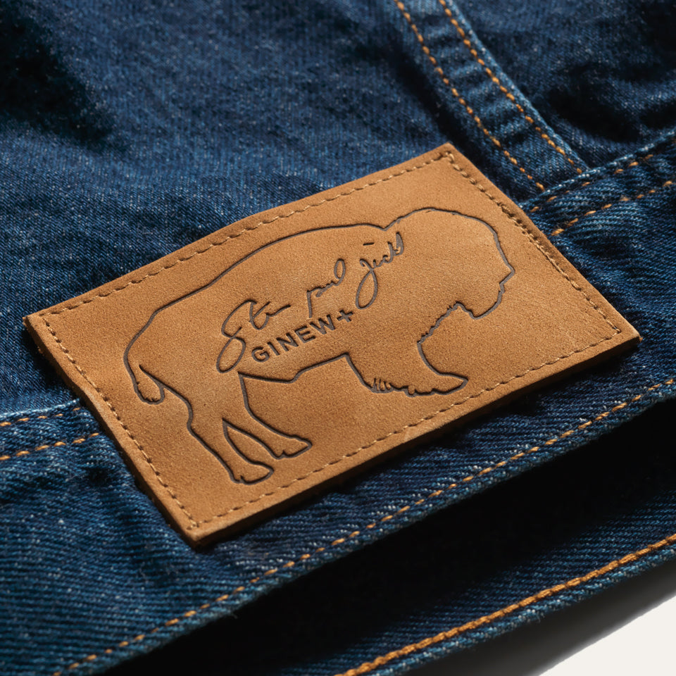 Buffalo leather patch close up on Native American designed denim jacket from Ginew + Steven Paul Judd with smiling arrow patch on right arm and color band at chest pocket