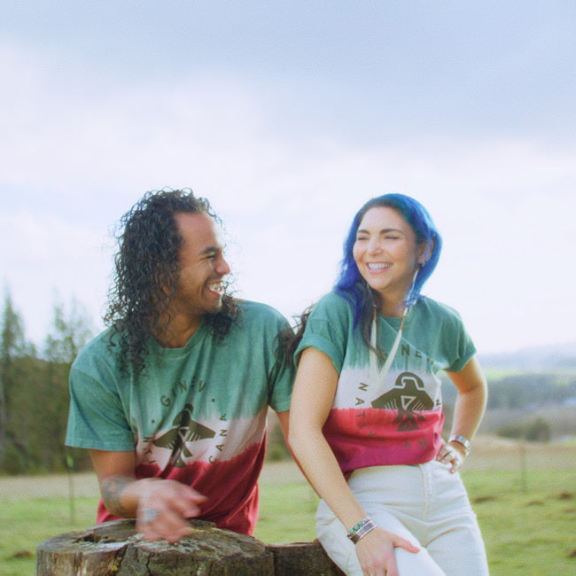 Models wearing all cotton tie dye tee in green cream and red smiling in field