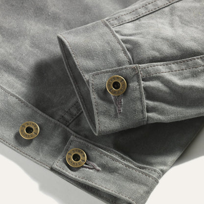 Detail view of sleeve cuff hardware and adjustable button on back hem.