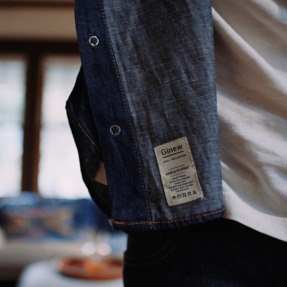 Close up of tag on Native American model wearing Western snap button shirt in chambray cotton 