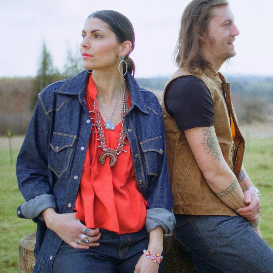 Chambray Western shirt in denim looking button-down on woman with man in brown wax canvas vest and black t-shirt